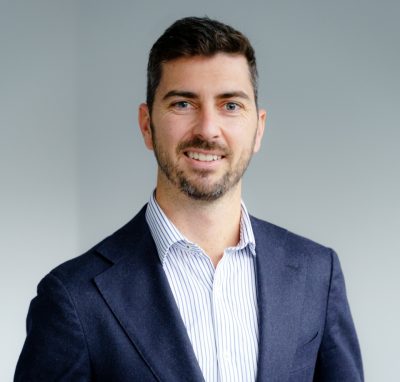 Professional man in a suit smiling for Therapia, related to Doctors & Medical Professionals CPD.