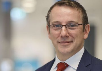Professional male doctor in a suit and tie at a medical facility.