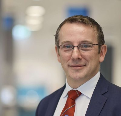 Professional male doctor in a suit and tie at a medical facility.
